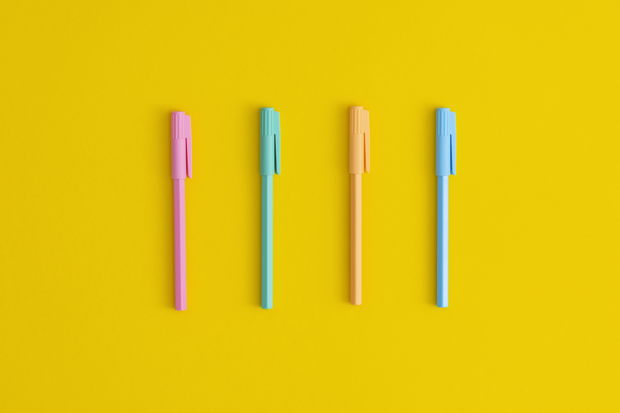 Multicolored pens on a yellow background